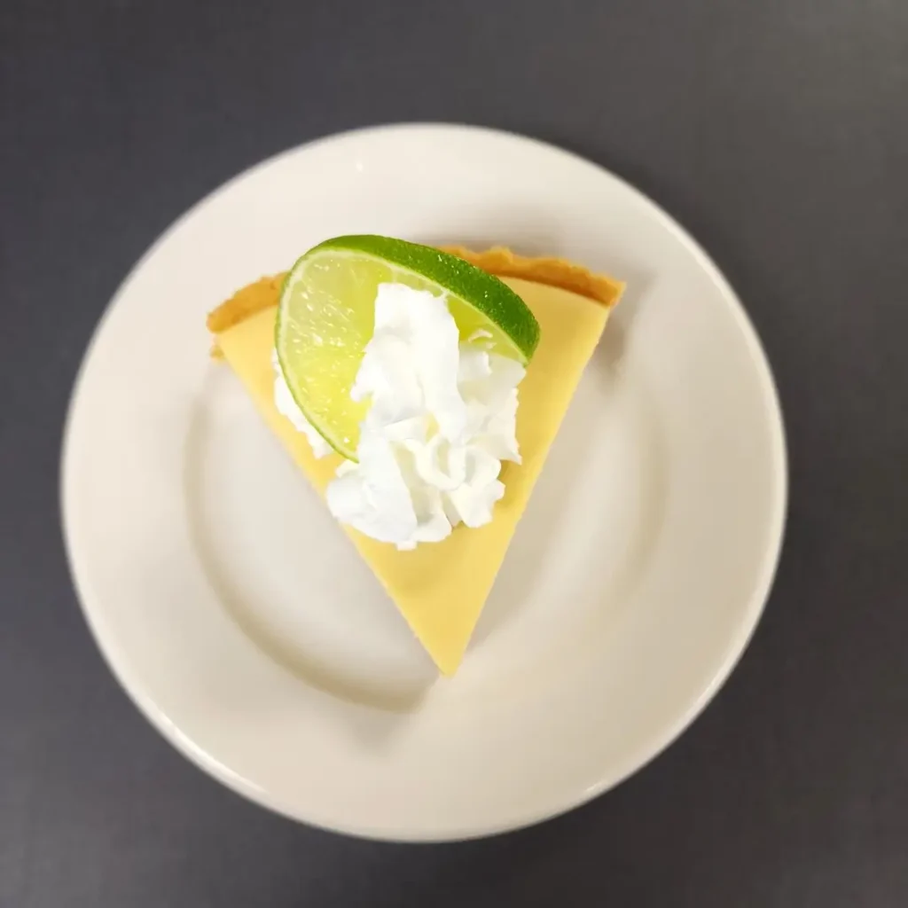 A slice of refreshing key lime pie topped with whipped cream